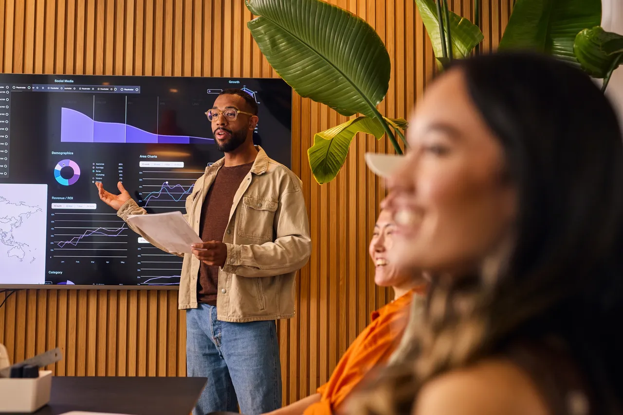 Man presenting data charts to colleagues
